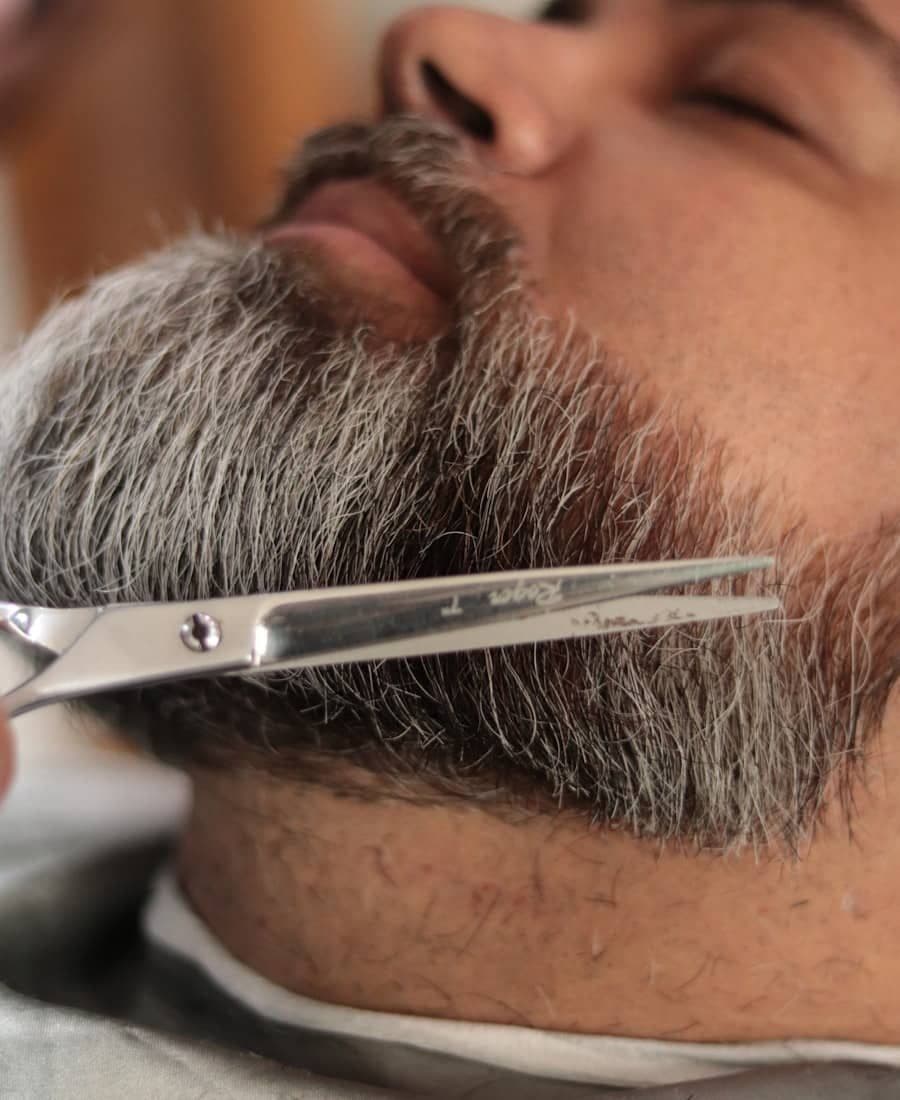 Barbeiro finalizando barba de cliente